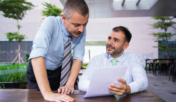 cheerful-successful-business-colleagues-discussing-documents